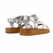 Δερμάτινα παιδικά πέδιλα για κορίτσια σε ασημί χρώμα με αυτοκόλλητο κούμπωμα και στρας και καφέ σόλα πίσω όψη σε λευκό φόντο.