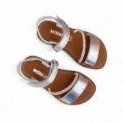 Δερμάτινα παιδικά πέδιλα για κορίτσια σε ασημί χρώμα με αυτοκόλλητο κούμπωμα και στρας και καφέ σόλα επάνω όψη σε λευκό φόντο.