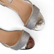 Γυναικεία πέδιλα σε ασημί χρώμα με γκλίτερ, κλειστή φτέρνα, λουράκι αστραγάλου, λουράκι με στρας και φάσα από γκλίτερ στα δάχτυλα και χαμηλό χοντρό τακούνι επάνω όψη σε λευκό φόντο.