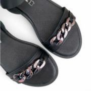 Γυναικεία σανδάλια με μαύρη σόλα, μαύρη φάσα με ασημί αλυσίδα στα δάχτυλα και μύρη μπαρέτα στο κουντεπιέ επάνω όψη σε λευκό φόντο.