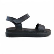 Γυναικεία δερμάτινα σανδάλια με μαύρη σόλα, μαύρη μπαρέτα με αυτοκόλλητο κούμπωμα και μαύρη φαρδιά κοφτή φάσα στα δάχτυλα πλάγια εξωτερική όψη σε λευκό φόντο.