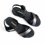 Γυναικεία δερμάτινα σνδάλια με μαύρη σόλα, μαύρη μπαρέτα και χιαστί λουράκια από μαύρο και και ατσαλί χρώμα πάνω όψη σε λευκό φόντο.