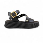 Γυναικεία σανδάλια δίσολα flatform με μαύρη σόλα και μαύρη μπαρέτα με χρυσή αγκράφα και λοξό λουρί στο κουντεπιέ με χρυσά τρουκς και μαύρη φάσα στα δάχτυλα πλάγια εξωτερική όψη σε λευκό φόντο.