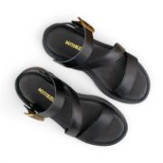 Γυναικεία σανδάλια δίσολα flatform με μαύρη σόλα, μαύρη μπαρετα με χρυσή αγκράφα,λοξό λουρί στο κουντεπιέ και μαύρη φάσα στα δάχτυλα επάνω  όψη σε λευκό φόντο.