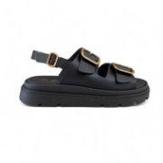 Γυναικεία σανδάλια δίσολα με μαύρη σόλα, δυο μαύρες φάσες με χρυσές αγκράφες και λουράκι με κούμπωμα στη φτέρνα πλάγια εξωτερική όψη σε λευκό φόντο.