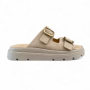 Γυναικείες παντόφλες δίσολες με μπεζ σόλα και δυο μπεζ λουριά με χρυσές αγκράφες πλάγια εξωτερική όψη σε λευκό φόντο.