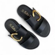 Γυναικείες παντόφλες δίσολες με διπλή φάσα και μεγάλο χρυσό μεταλλικό διακοσμητικό σε όλο μαύρο χρώμα επάνω όψη σε λευκό φόντο.