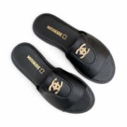 Γυναικείες φλατ παντόφλες σε όλο μαυρο χρώμα με φαρδιά φάσα και μικρό χτυσό διακοσμητικό επάνω όψη σε λευκό φόντο.