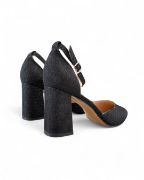 Μυτερές μαύρες γόβες με κλειστά δάχτυλα και κλειστή φτέρνα με γκλίτερ χοντρό τακούνι και λουράκι στον αστράγαλο πίσω όψη σε λευκό φόντο.