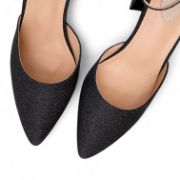 Μυτερές μαύρες γόβες με κλειστά δάχτυλα και κλειστή φτέρνα με γκλίτερ χοντρό τακούνι και λουράκι στον αστράγαλο επάνω όψη σε λευκό φόντο.