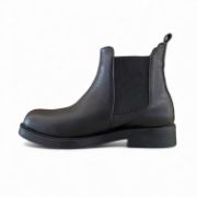 Δερμάτινα μποτάκια chelsea σε μαύρο χρώμα με λάστιχα στην εσωτερική και εξωτερική πλευρά με στρογγυλή μύτη πλάγια εσωτερική όψη σε λευκό φόντο.