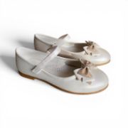 Παιδικές μπαλαρίνες σε ιβουάρ χρώμα με ανατομικό πάτο μπαρέτα με αυτοκόλλητο κούμπωμα στο κουντεπιέ,λεπτή σόλα σε ανοιχτή καφέ απόχρωση και διακοσμητικό φιογκάκι με γκλίτερ και στρας σε λευκό φόντο.