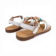 Παιδικά πέδιλα για κορίτσια σε λευκό χρώμα με μπεζ σόλα και πάτο.Έχουν λεπτά λουράκια στον αστράγαλο και κούμπωμα με τόκα.Ένα λεπτό λουράκι κάθετα στο κουντεπιέ με γαλάζιες,καφέ και μπλέ χάντρες και τρία λεπτά λουράκια στα δάχτυλα μπλεγμένα μεταξύ τους.Πίσω όψη σε λευκό φόντο.