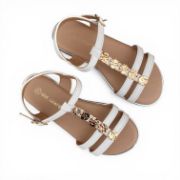 Παιδικά πέδιλα σε λευκό χρώμα με μπεζ σόλα και πάτο.Έχουν λεπτά λουράκια στον αστράγαλο με κούμπωμα με τόκα.Λεπτό λουράκι κάθετα στο κουντεπιέ με χρυσά στρογγυλά μεταλλικά διακοσμητικά και δύο λεπτά λουράκια στα δάχτυλα το ένα κάτω από το άλλο.Επάνω όψη σε λευκό φόντο.